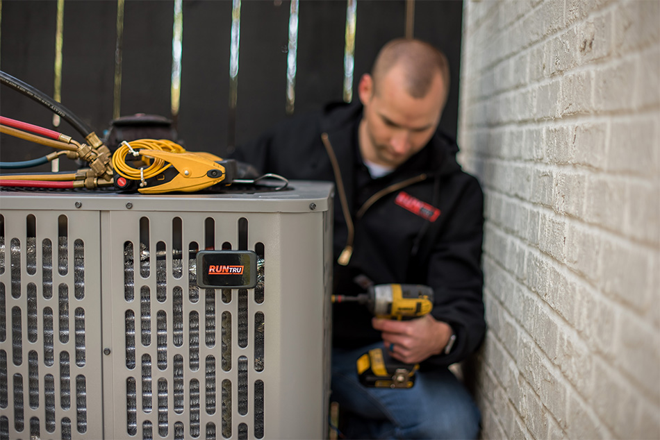 Technician maintaining residential air conditioning equipment